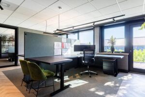 Groot hoekbureau met een donker blad en een zwarte poot.